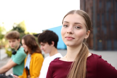 Photo of Teenagers spending time together outdoors, selective focus