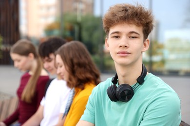 Photo of Teenagers spending time together outdoors, selective focus