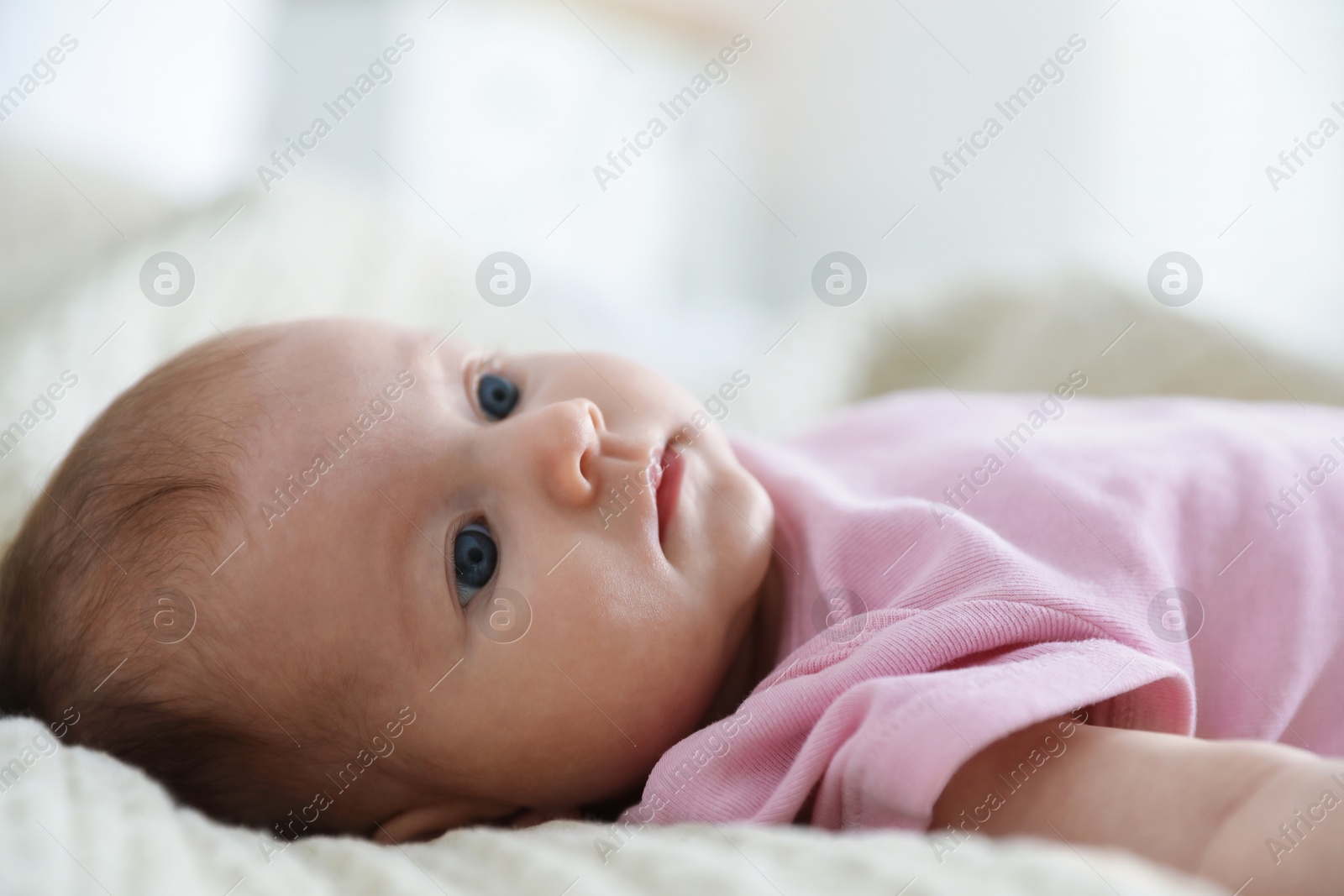 Photo of Cute newborn baby lying on bed indoors