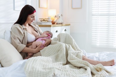 Photo of Mother with her newborn baby on bed indoors