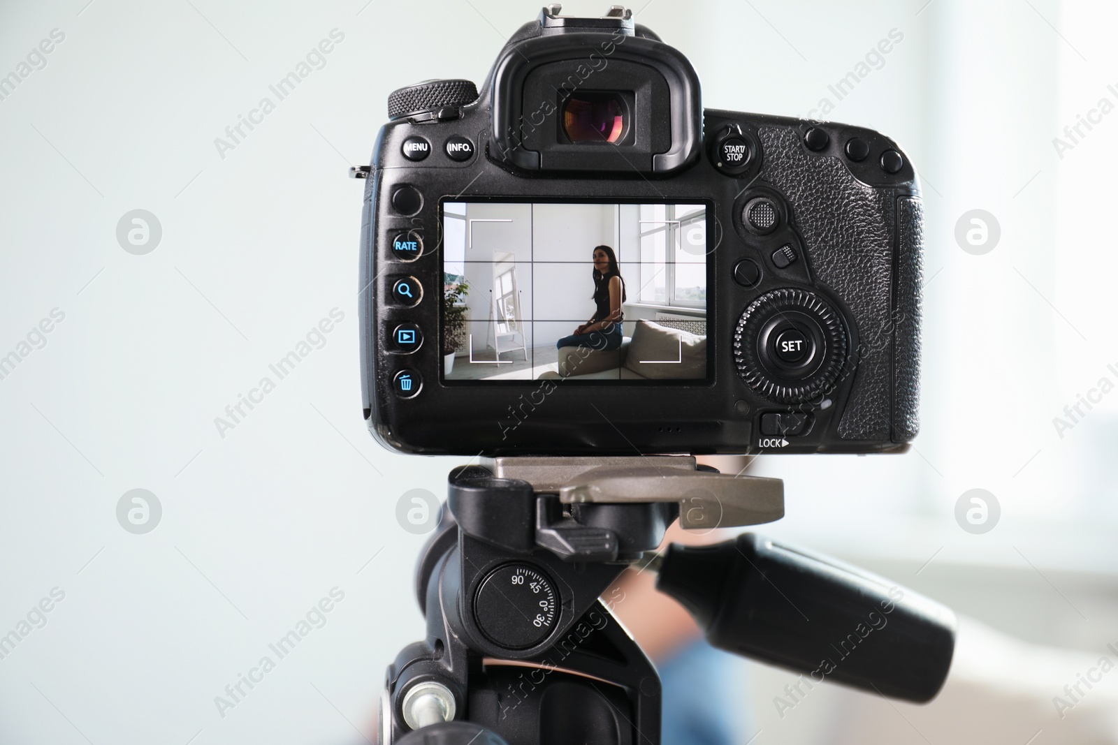 Woman on sofa in studio, focus on video camera recording her Photo of Woman on sofa in studio, focus on video camera recording her