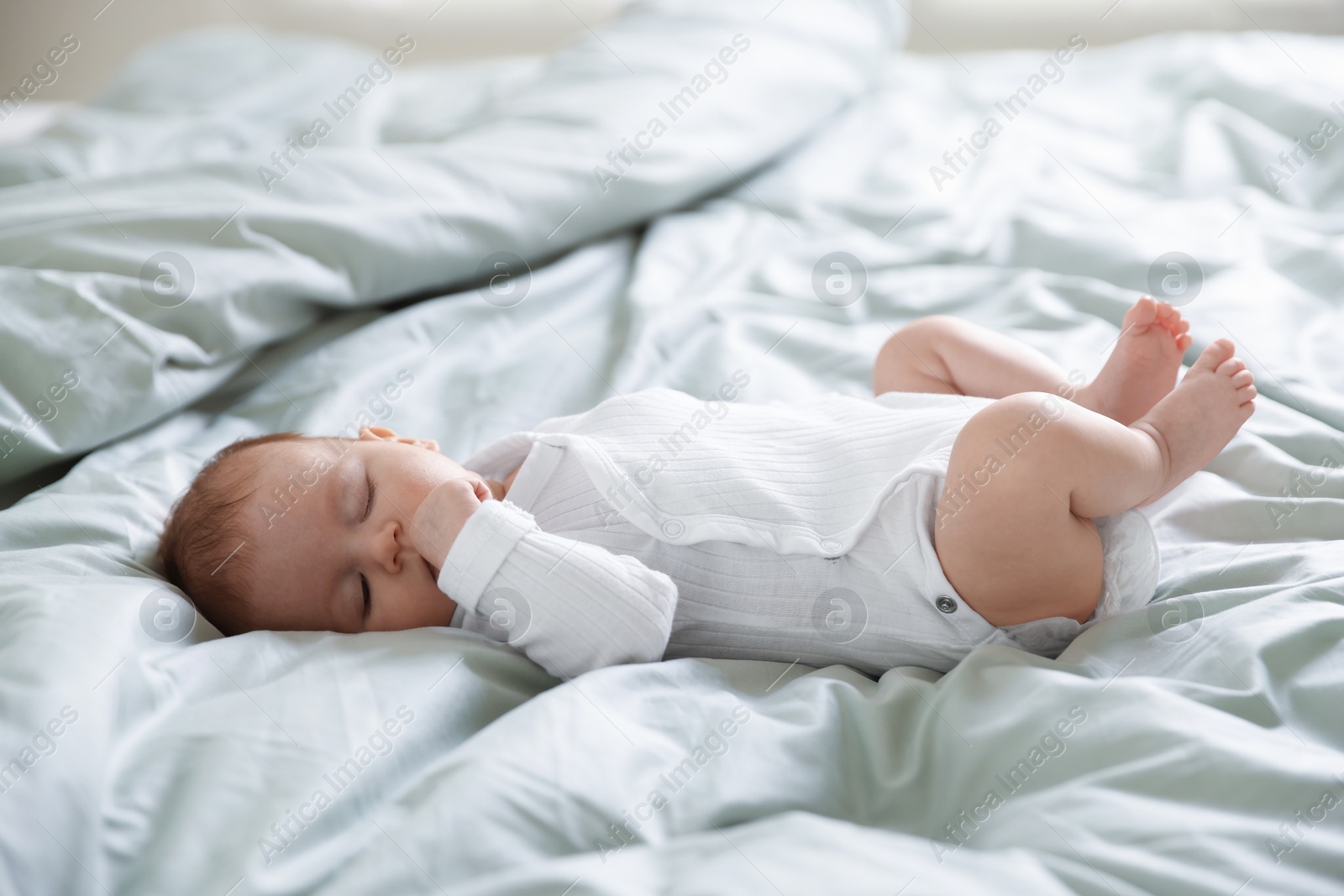 Cute sweet newborn baby sleeping on bed Photo of Cute sweet newborn baby sleeping on bed