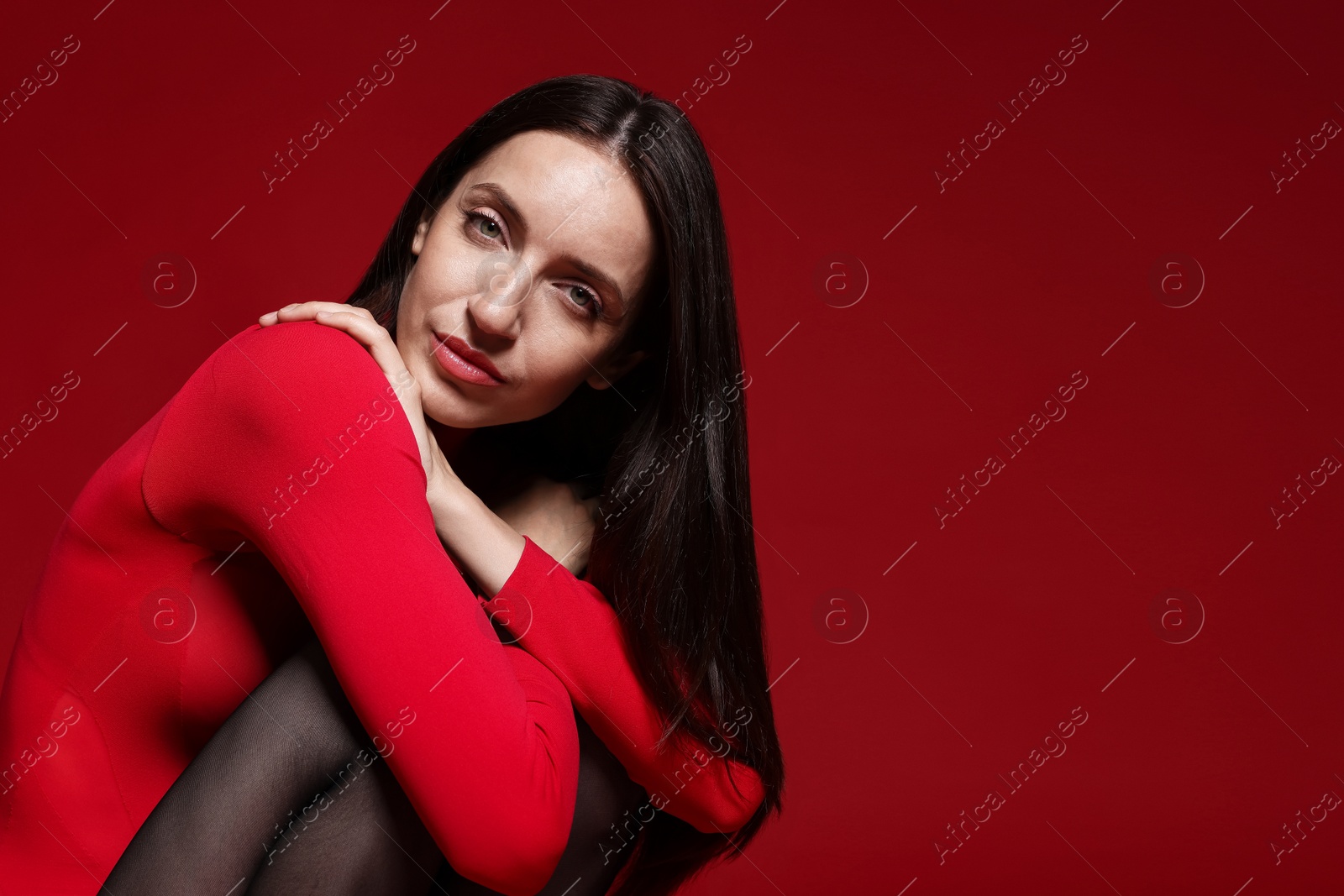 Portrait of beautiful woman in stylish outfit on red background, space for text Photo of Portrait of beautiful woman in stylish outfit on red background, space for text