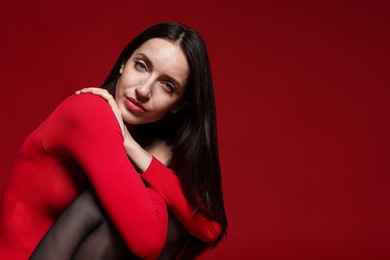 Photo of Portrait of beautiful woman in stylish outfit on red background, space for text