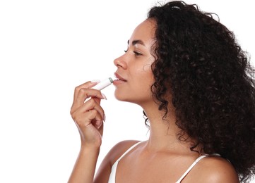 Photo of Beautiful woman applying lip balm onto her lips on white background