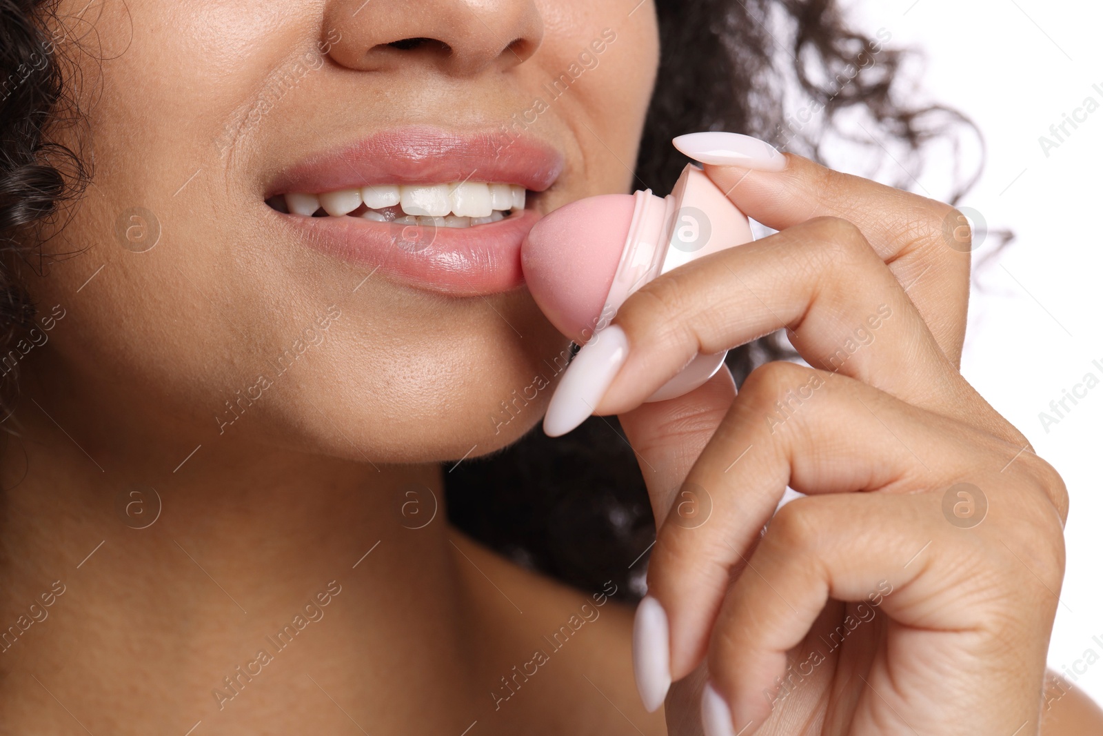 Smiling woman applying lip balm onto her lips on white background, closeup Photo of Smiling woman applying lip balm onto her lips on white background, closeup