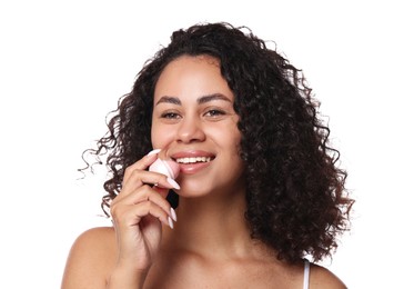 Photo of Smiling woman applying lip balm onto her lips on white background