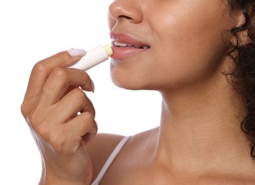 Photo of Smiling woman applying lip balm onto her lips on white background, closeup