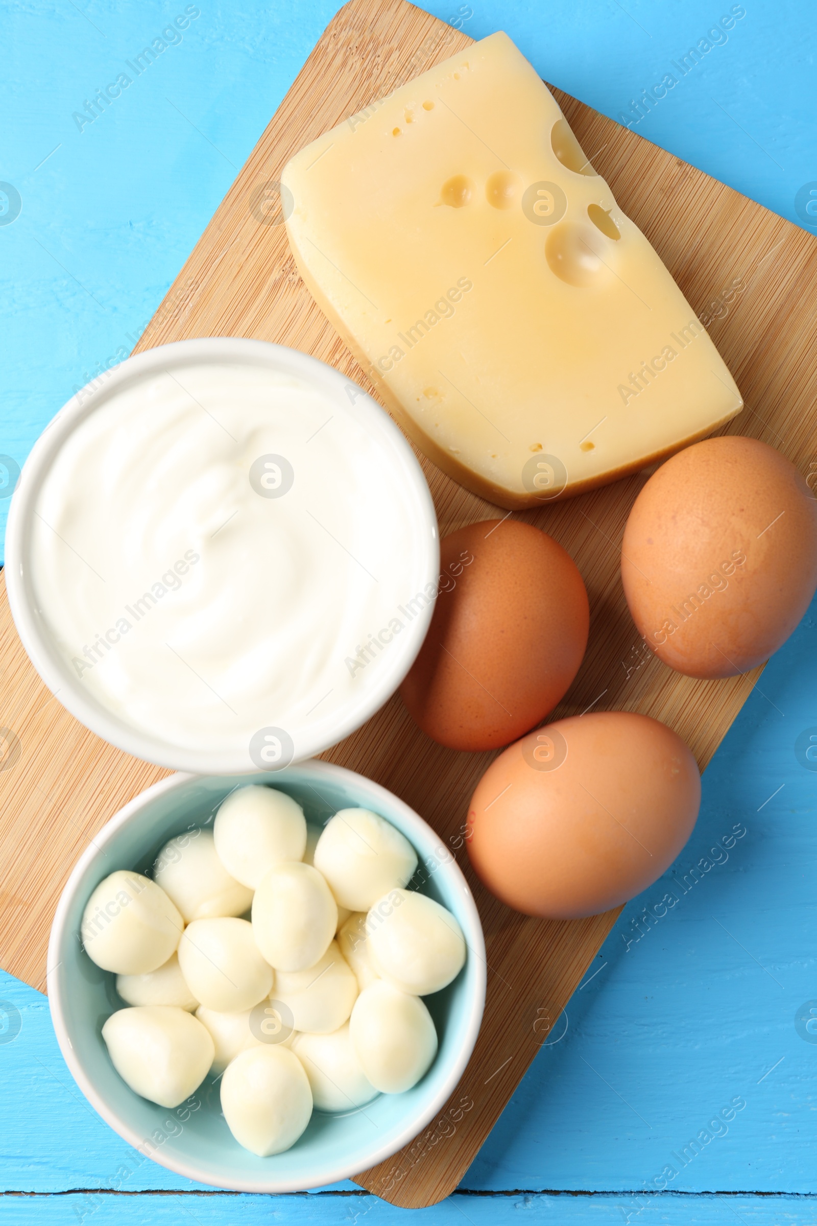Different dairy products and eggs on light blue wooden table, top view Photo of Different dairy products and eggs on light blue wooden table, top view