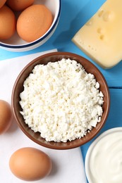Photo of Different dairy products and eggs on light blue wooden table, flat lay