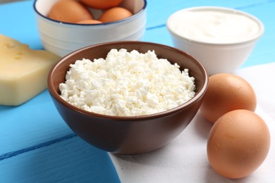 Photo of Different dairy products and eggs on light blue wooden table, closeup