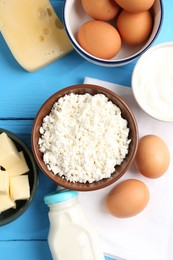 Photo of Different dairy products and eggs on light blue wooden table, flat lay
