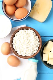 Photo of Different dairy products and eggs on light blue wooden table, flat lay