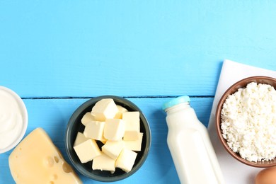 Photo of Different dairy products on light blue wooden table, flat lay. Space for text