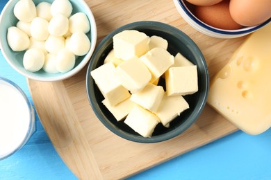 Photo of Different dairy products and eggs on light blue wooden table, flat lay