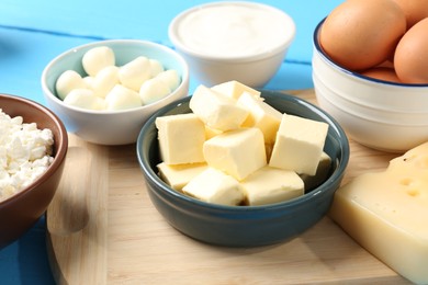 Photo of Different dairy products and eggs on light blue wooden table, closeup