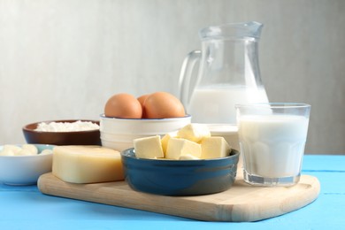 Photo of Different dairy products and eggs on light blue wooden table, closeup
