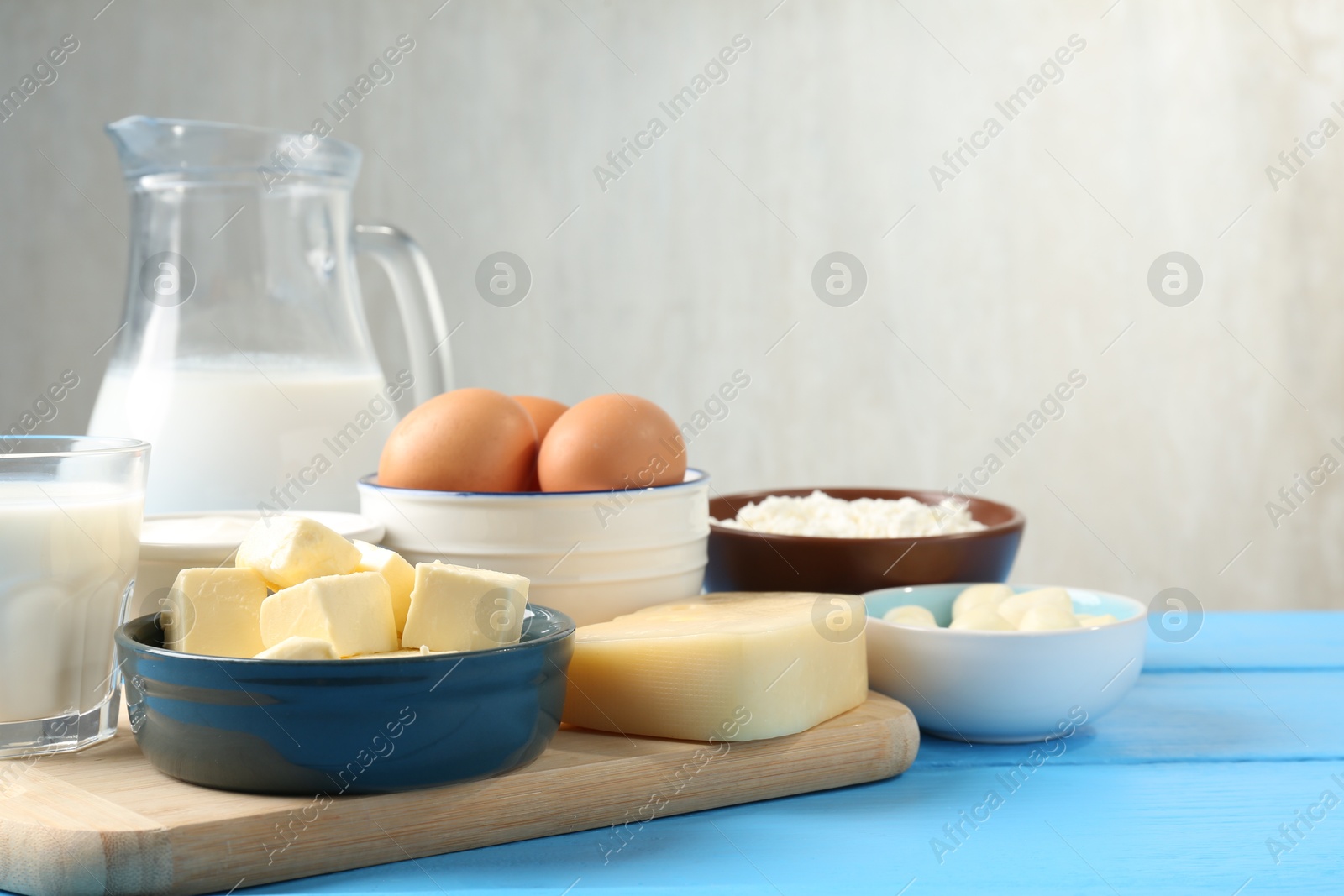 Different dairy products and eggs on light blue wooden table, closeup. Space for text Photo of Different dairy products and eggs on light blue wooden table, closeup. Space for text