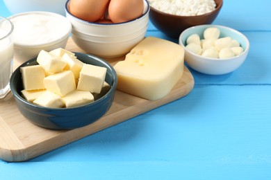 Photo of Different dairy products and eggs on light blue wooden table, closeup. Space for text