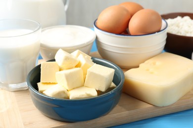 Photo of Different dairy products and eggs on light blue table, closeup