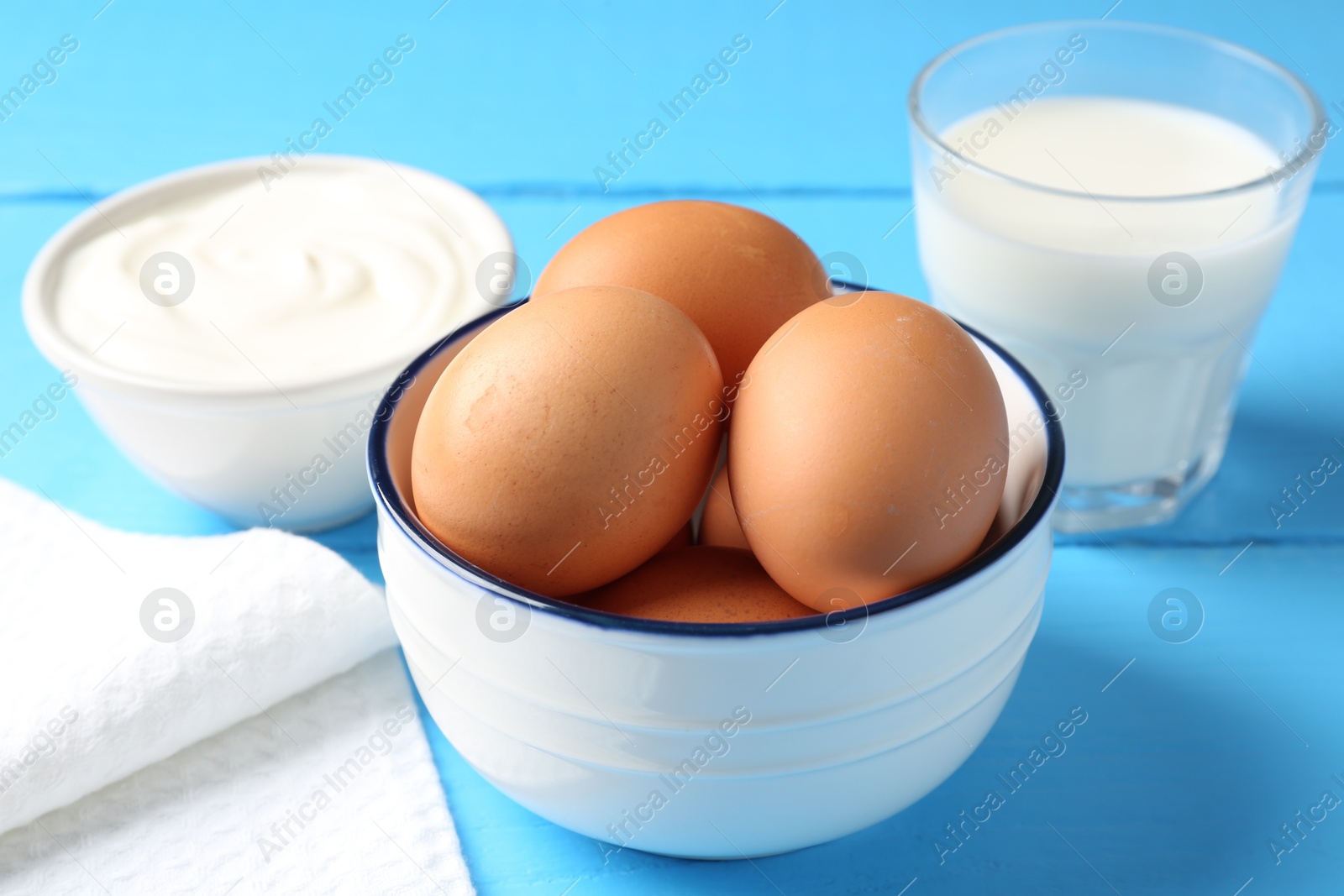 Dairy products and eggs on light blue wooden table, closeup Photo of Dairy products and eggs on light blue wooden table, closeup