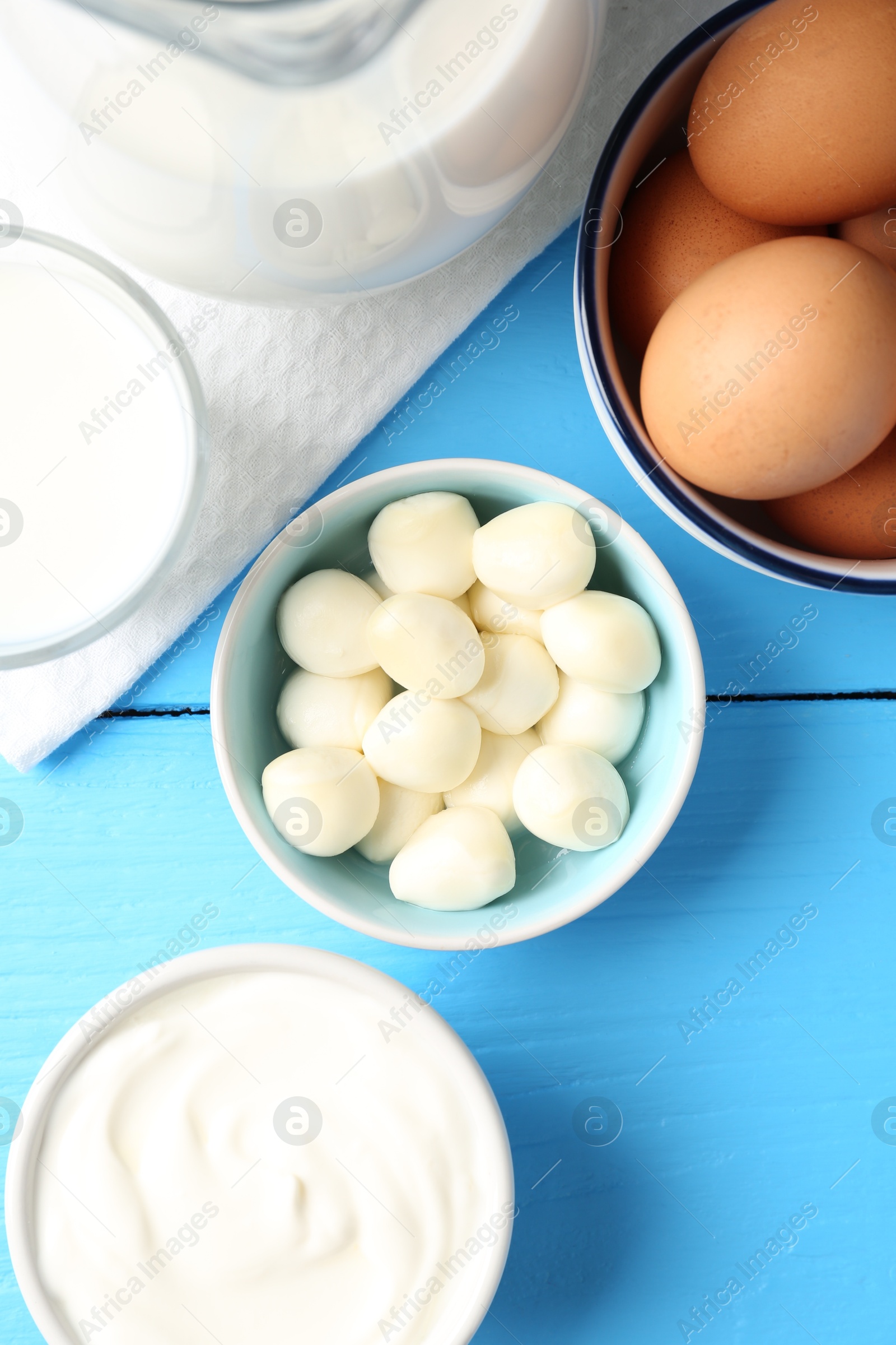 Different dairy products and eggs on light blue wooden table, flat lay Photo of Different dairy products and eggs on light blue wooden table, flat lay