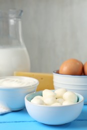 Photo of Different dairy products and eggs on light blue wooden table, closeup