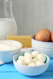 Photo of Different dairy products and eggs on light blue wooden table, closeup