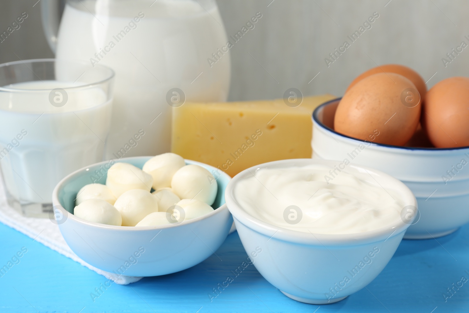 Different dairy products and eggs on light blue wooden table, closeup Photo of Different dairy products and eggs on light blue wooden table, closeup