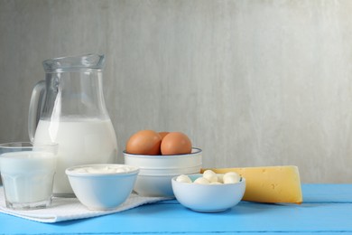 Photo of Different dairy products and eggs on light blue wooden table