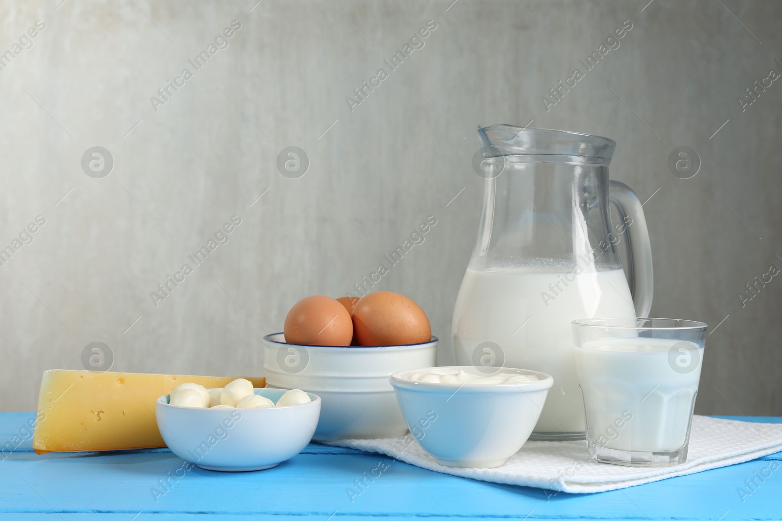 Different dairy products and eggs on light blue wooden table Photo of Different dairy products and eggs on light blue wooden table