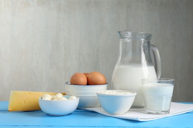 Photo of Different dairy products and eggs on light blue wooden table