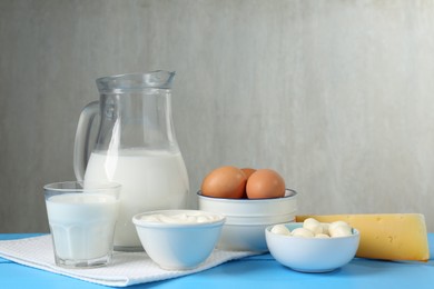 Photo of Different dairy products and eggs on light blue wooden table