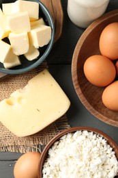 Photo of Different dairy products and eggs on grey wooden table, flat lay