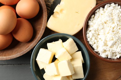 Photo of Different dairy products and eggs on grey wooden table, flat lay