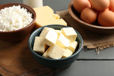 Photo of Different dairy products and eggs on grey wooden table, closeup