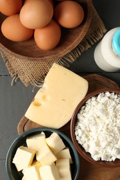 Photo of Different dairy products and eggs on grey wooden table, flat lay