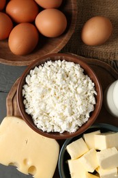 Photo of Different dairy products and eggs on grey wooden table, flat lay