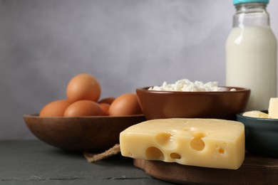 Photo of Different dairy products and eggs on grey wooden table, closeup