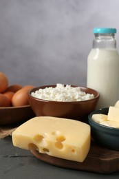 Photo of Different dairy products and eggs on grey wooden table, closeup