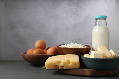 Photo of Different dairy products and eggs on grey wooden table, closeup