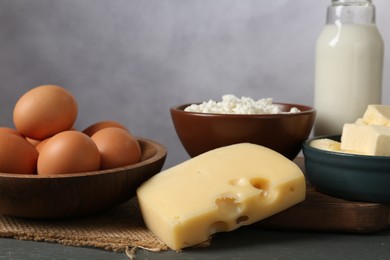 Photo of Different dairy products and eggs on grey wooden table, closeup