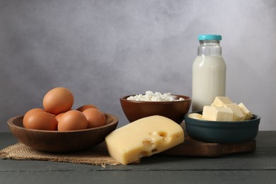 Photo of Different dairy products and eggs on grey wooden table