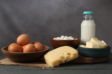 Photo of Different dairy products and eggs on grey wooden table