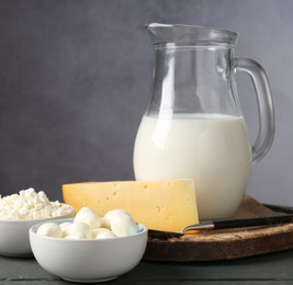Photo of Different dairy products on grey wooden table, closeup
