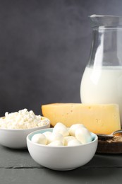 Photo of Different dairy products on grey wooden table, closeup