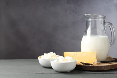 Photo of Different dairy products on grey wooden table, space for text