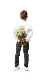 Photo of Little boy hiding bouquet of beautiful chamomile flowers on white background, back view