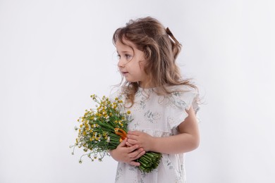 Photo of Cute little girl with bouquet of beautiful chamomile flowers on white background