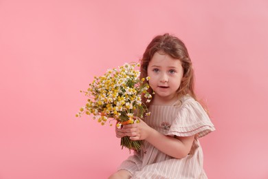 Photo of Cute little girl with bouquet of beautiful chamomile flowers on pink background